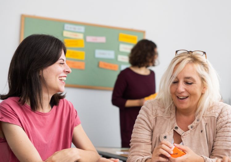 A1 German courses in Frankfurt – two participants in conversation. In the background, the teacher is speaking with other participants.