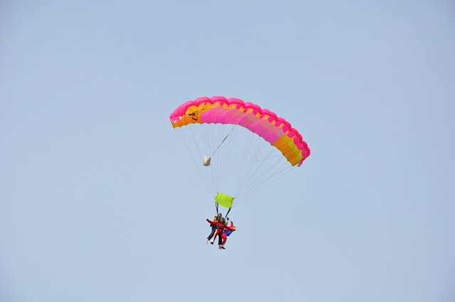 Person mit Fallschirm hoch am Himmel – Symbolbild für Mut und Überwindung von Unsicherheit beim Deutsch sprechen lernen in Frankfurt.